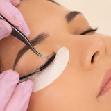 Lash professional gently isolating extensions during treatment.