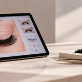 Tablet showing a digital eyelash design alongside lash extension trays and precision tweezers.