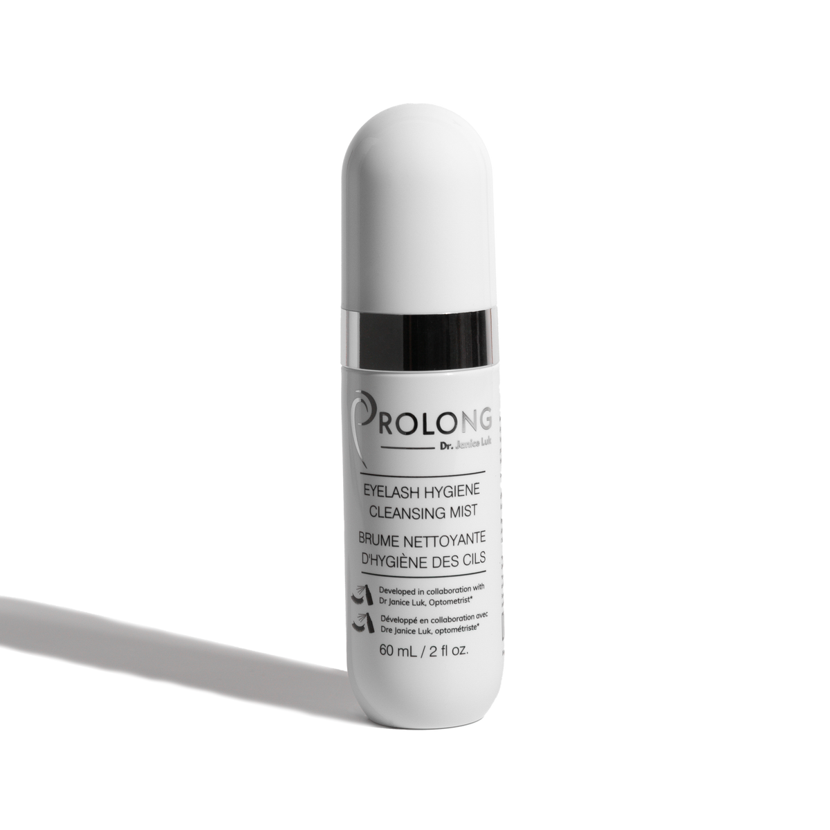 A white cylindrical cosmetic bottle with a ribbed cap and a black collar, labeled 'PROLONG DR. JANICE LUK EYELASH HYGIENE CLEANSING MIST' on a clean white background with a soft shadow.